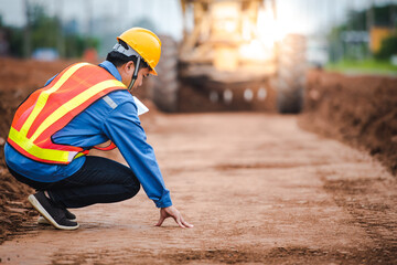 Asian engineers watch road rebuilding and inspect the construction of the road at the construction...