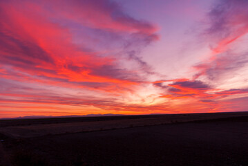 Beautiful picture of a sunset in a partial cloudy day with purple and orange colors. Great dawn