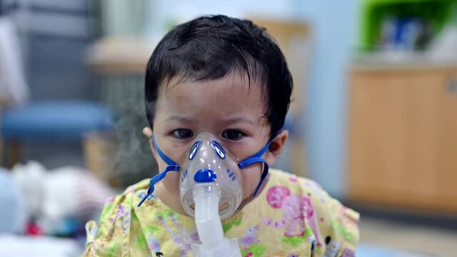 Asian baby was sick as Respiratory Syncytial Virus (RSV) in kid hospital. Thai little girl having inhaler containing medicine for stop coughing and disease flu.