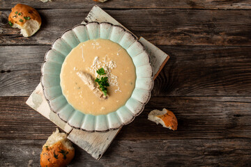 Delicious chicken creamy soup with bread on wooden table. Food recipe background. space for text. top view