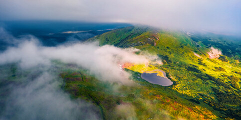 Panoramic view from flying drone of Nesamovyte Lake and Turkul Peak. Foggy morning scene of Carpathian mountains, Ukraine, Europe. Beauty of nature concept background..