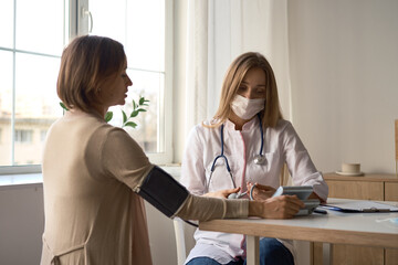 Fototapeta premium Doctor measuring blood pressure of her pregnant patient. High quality photo
