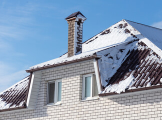 Snow on the roof of the house.