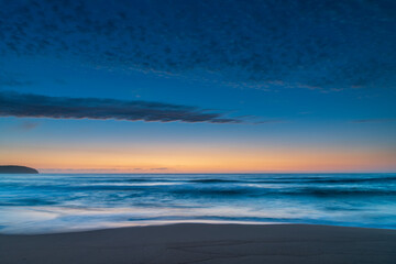 Fototapeta na wymiar High cloud, partial moon and a pretty blue dawn at the beach