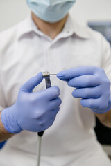 The dentist inserts the pin into the drill