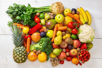 White wooden table full of fresh assorted fruit and vegetable. Colorful heap of raw nutritious food on light background. Concept of vitamin and health in flatlay composition.