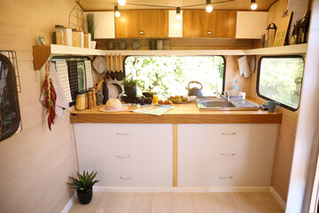 Stylish kitchen interior with different jars and utensils in modern trailer. Camping vacation