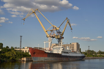 Obraz premium old and abandoned metal vessel in Mykolaiv Ukraine. rusted metal. old ship and cranes