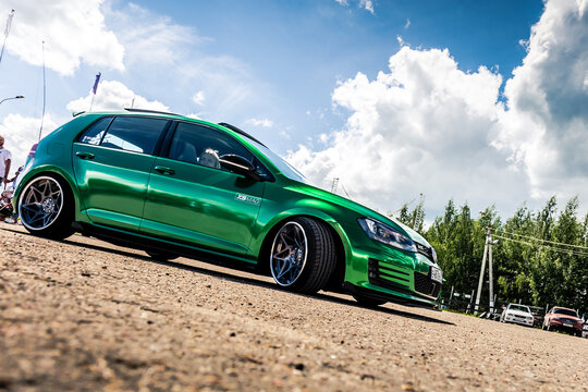 Moscow, Russia - July 06, 2019: Tuned Golf 7 tightened into a green vinyl film. Installed exclusive wheels, air suspension. Lowrider in the parking lot. Side view