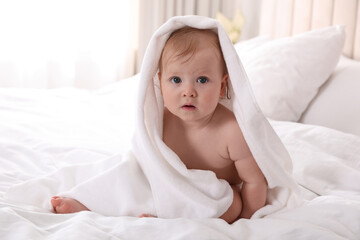 Fototapeta na wymiar Cute little baby with soft towel on bed after bath