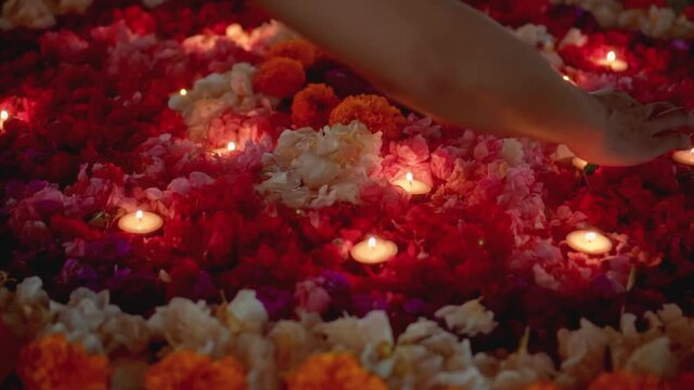 lit a candle in a circle of colorful flowers in the evening