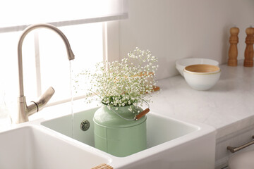 Obraz na płótnie Canvas Bouquet of gypsophila flowers in sink. Kitchen interior design