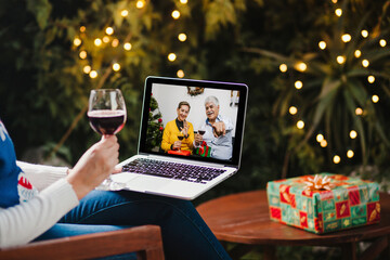 Latin parents with hispanic daughter with wineglass on Christmas video call