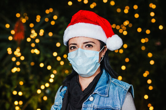 Latin Woman At A Christmas Party Wearing A Hat And A Face Mask