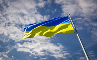 Beautiful national state flag of Ukraine fluttering at sky background. Low angle close-up Ukraine flag 3D artwork.