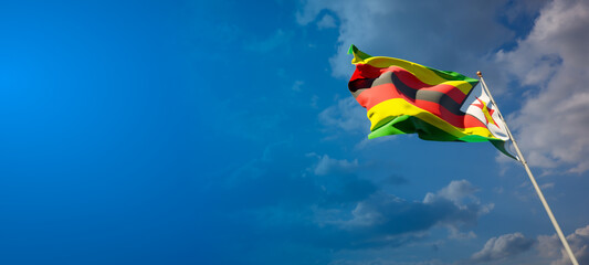 Beautiful national state flag of Zimbabwe with blank space. Zimbabwe flag on wide background with place for text 3D artwork. - obrazy, fototapety, plakaty
