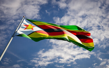 Beautiful national state flag of Zimbabwe fluttering at sky background. Low angle close-up Zimbabwe flag 3D artwork.