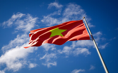 Beautiful national state flag of Vietnam fluttering at sky background. Low angle close-up Vietnam flag 3D artwork.