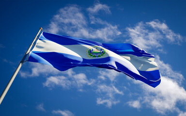 Beautiful national state flag of El Salvador fluttering at sky background. Low angle close-up El Salvador flag 3D artwork.