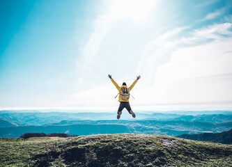 Successful man jumping on the top of the mountain - Happy hiker celebrating success - obrazy, fototapety, plakaty