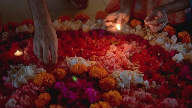lit a candle in a circle of colorful flowers in the evening