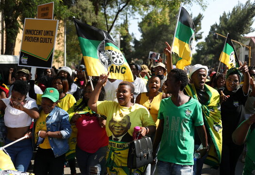 ANC supporters carry placards and flags ahead of the court appearance of Ace Magashule, the secretary general of South Africa's ruling African National Congress, at the Bloemfontein high court in the Free State province
