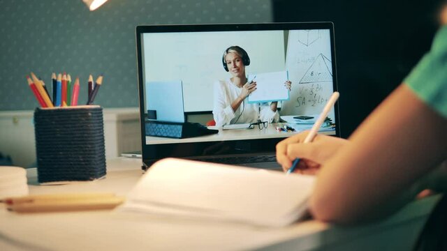Close up shot of a little student taking part in an online lesson. Distance education, online education, online class concept.