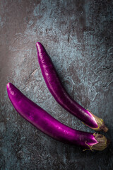 Japanese Eggplants, fresh aubergines on dark background