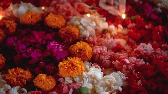 lit a candle in a circle of colorful flowers in the evening