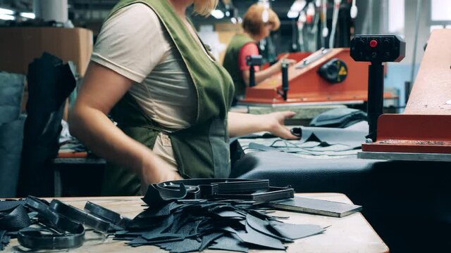 Footwear factory workers are cutting out patterns for boots