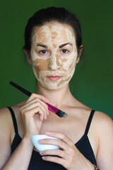  young brunette woman with a clay homemade mask on her face