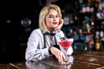 Girl bartender mixes a cocktail on the alehouse