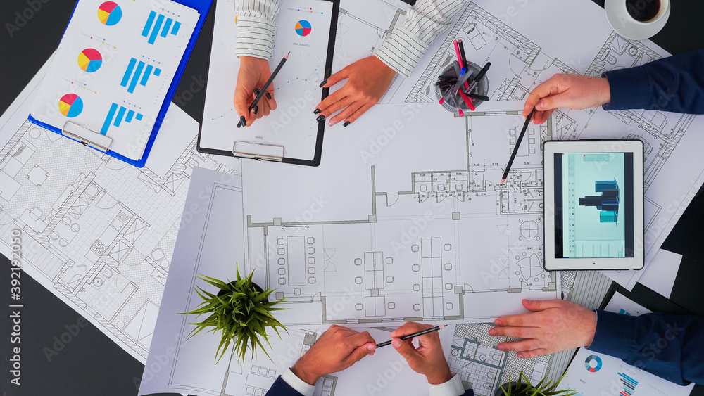 Poster top view of architects and engineers creating a blueprint to build modern building equipped with the