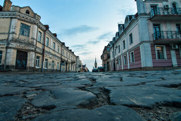 Street in the oldn town with close up on the old stone pavement. Selective focus, low DOF