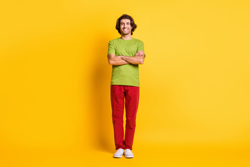 Fototapeta premium Full length body size photo of smiling confident man with crossed hands wearing colorful clothes isolated vibrant yellow color background