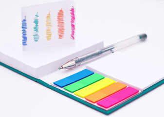 Vivid pencils, pens and note book on a white background.