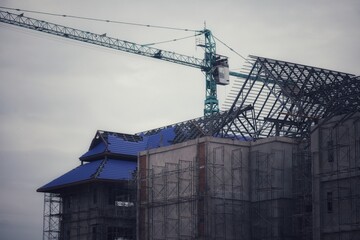 New construction site with crane Sunset sky background Steel frame structure, steel beam Building a large building at the construction site Construction machinery