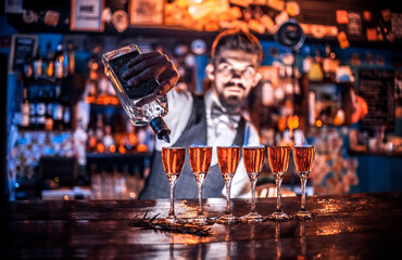 Focused barman mixes a cocktail in cocktail bars
