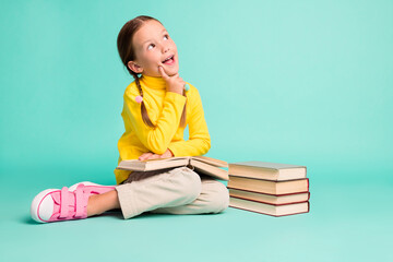 Full size photo of brown haired little stylish girl sit floor finger cheek look empty space wear...