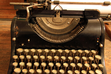 Very old, historic typewritter machine and white paper in.