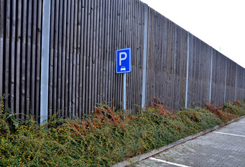 soundproof wall made of wooden slat concrete fence made of gray blocks on the street. noise from...