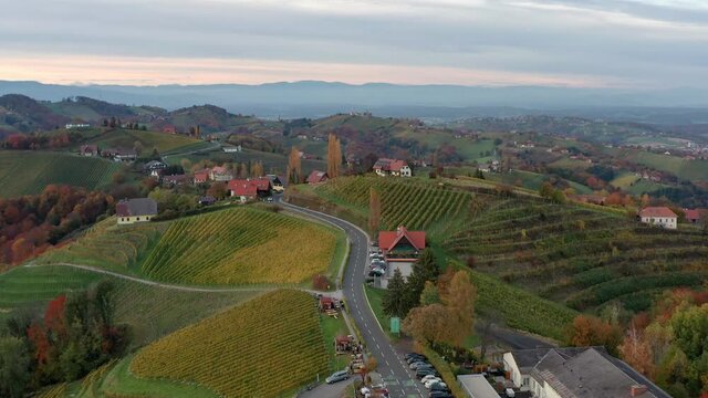 Aerial view of Austrian vilage Kitzeck im Sausal on vineyard durring autumn sunset region in Styria. The top of grape hill with alps in background.