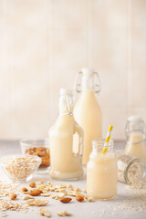 Fototapeta na wymiar Dairy free alternative nut milk in glass bottles on a gray background. Healthy vegan food concept.