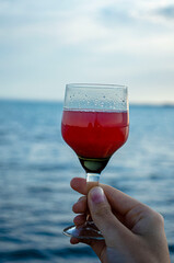 a glass of wine on the background of the sea, the beach, the lake, drinks