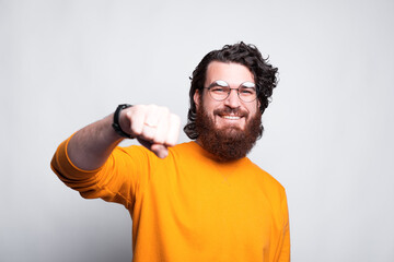 Man smiling at the camera holding a punch as a hello sign during the pandemic .