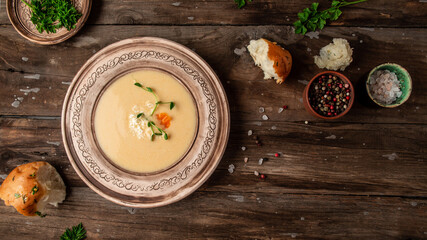 Fototapeta na wymiar Chicken Cream Soup. Traditional recipe cheese soup with pea sprouts in bowl on wooden background. Food recipe background. space for text. top view