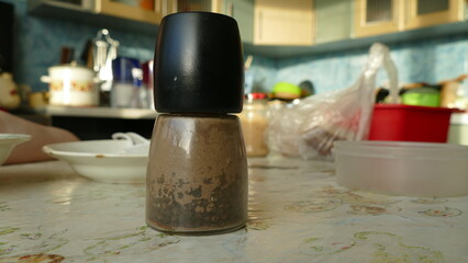 a jar of black pepper is on the table