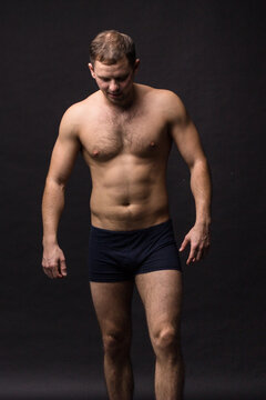 Handsome man in underwear on the black background. Muscular and athletic. 
Underwear man portrait. Male underwear model in studio


