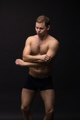 Fototapeta na wymiar Handsome man in underwear on the black background. Muscular and athletic. Underwear man portrait. Male underwear model in studio