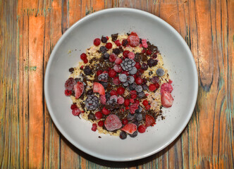 Bowl of oatmeal pudding with chocolate and berries.